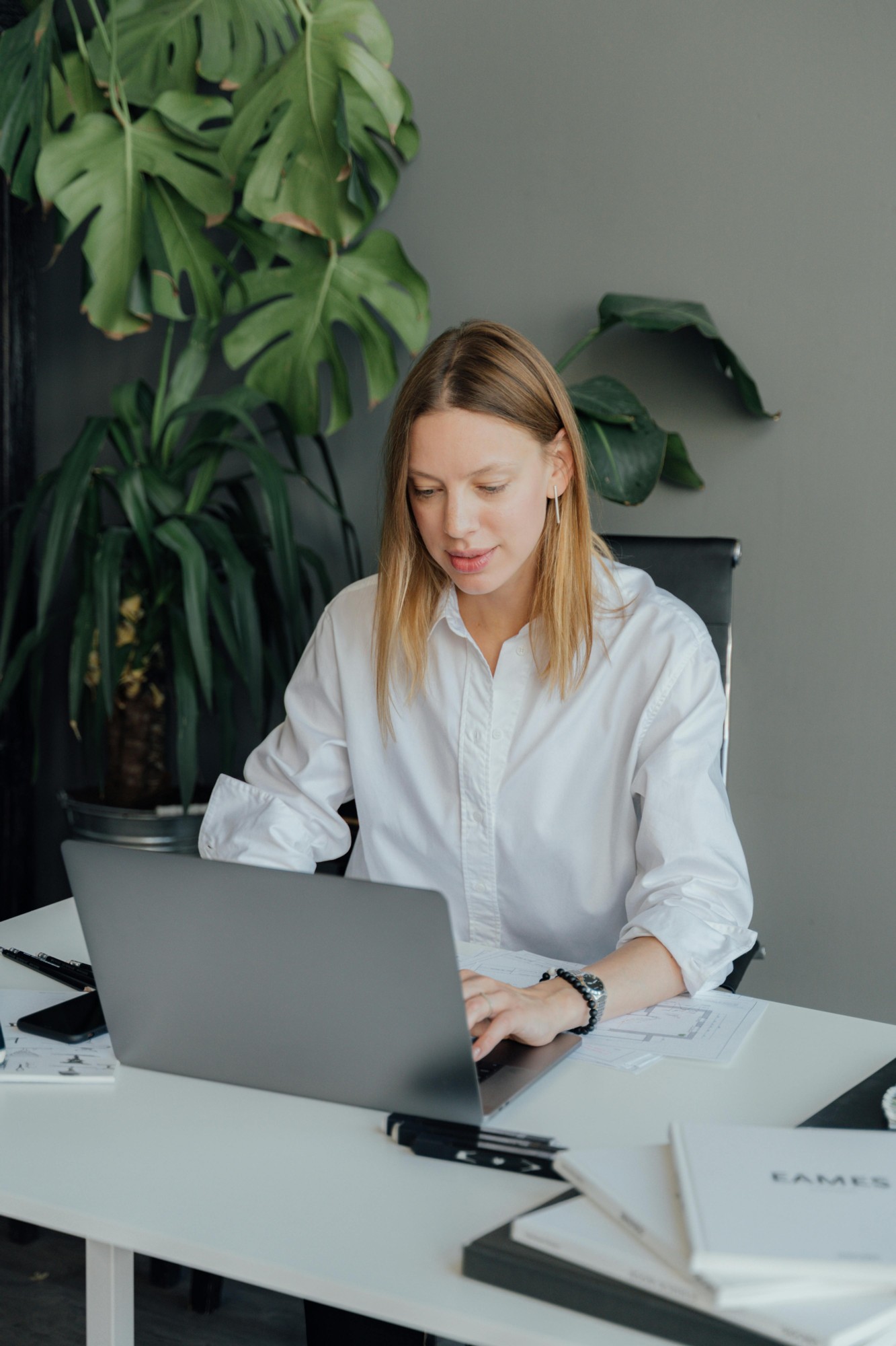 Blonde woman sitting at a desk and working on the laptop