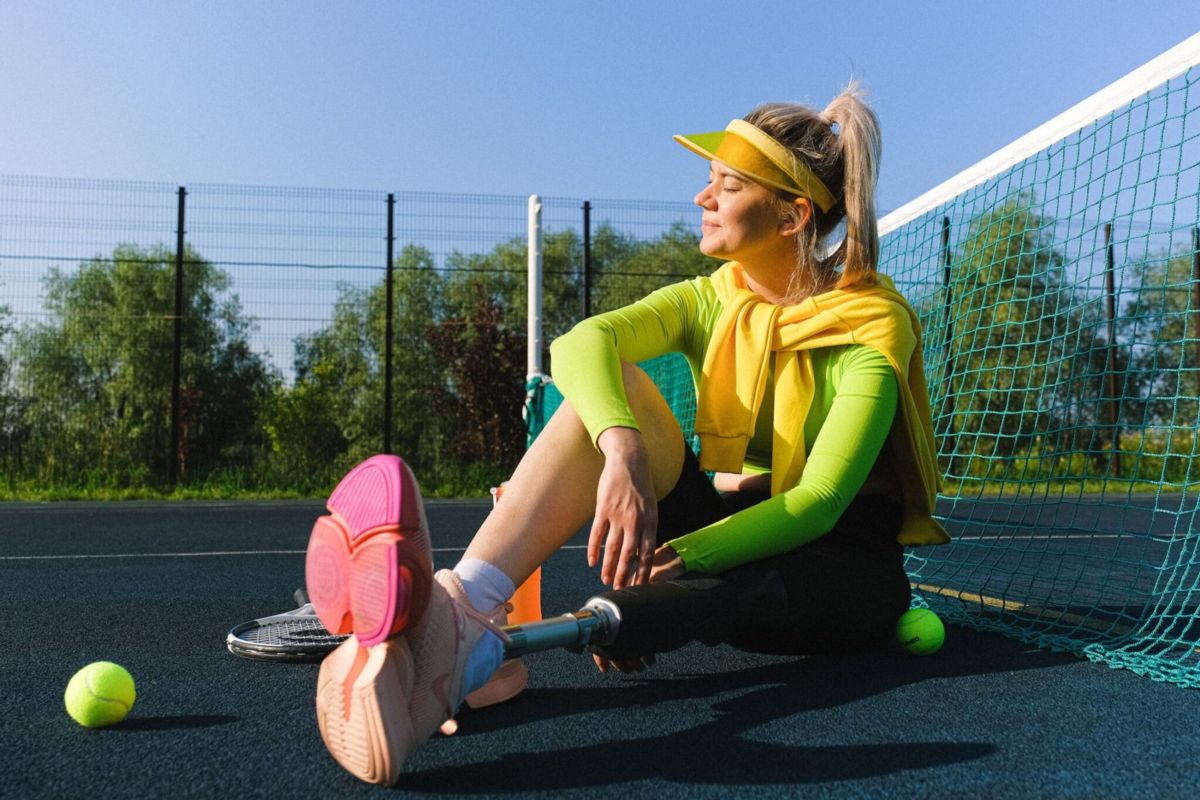 Woman sitting in the sun on a tennis court