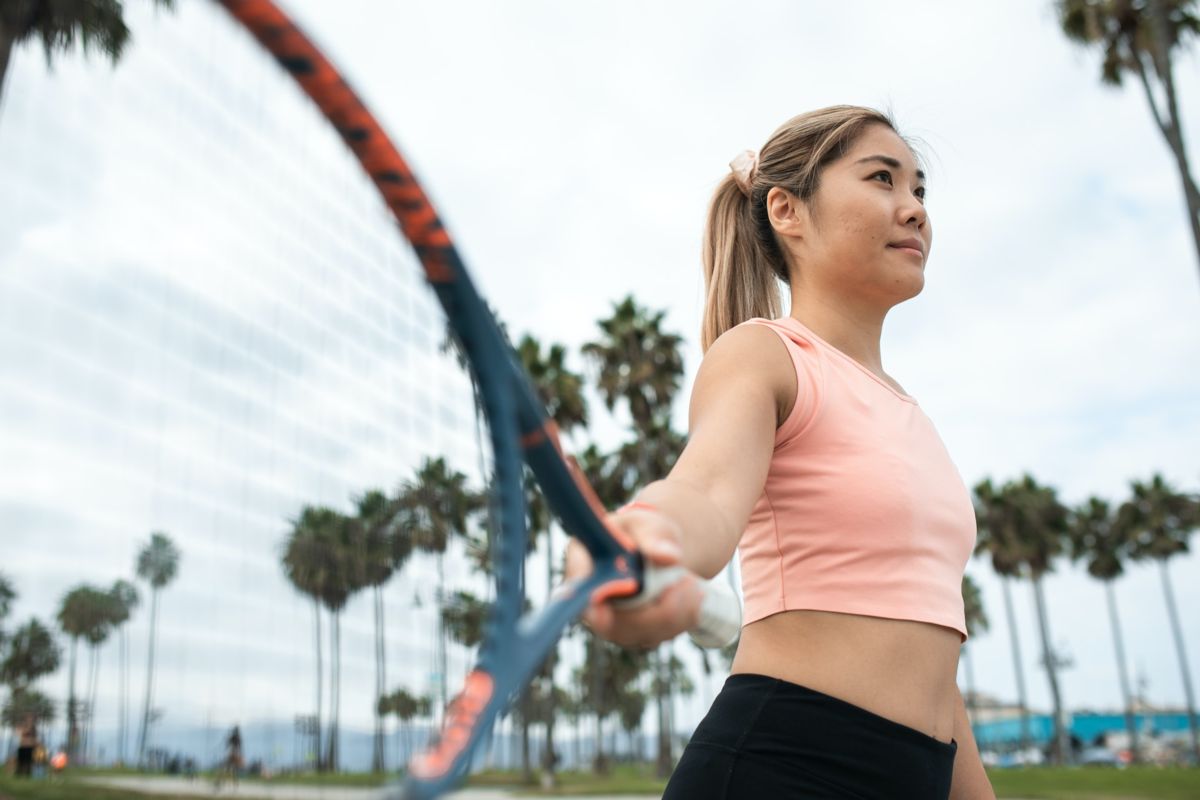 Woman in pink tank top working out in private club fitness area